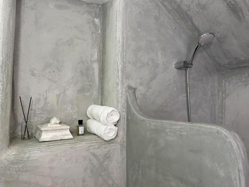 a bathroom with a shower and towels on a shelf at Sifnos Blue Horizon House - Endless Blue in Apollonia