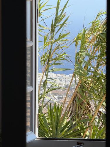 a window with a view of a city at Sifnos Blue Horizon House - Endless Blue in Apollonia
