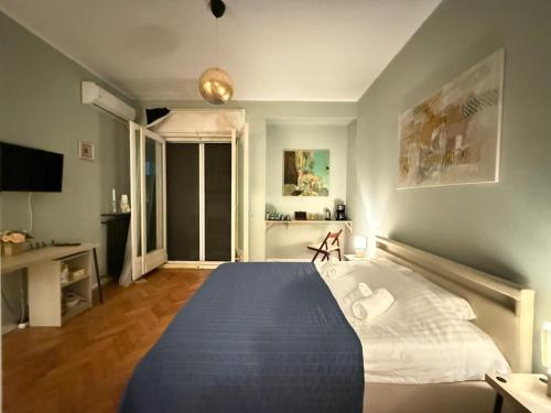 a bedroom with a large bed with a blue blanket at Cisimigu Garden Studio in Bucharest