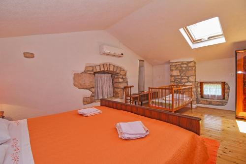 a bedroom with a large bed and a fireplace at Erika in Šumber (Haus für 4-6 Personen) in Nedeščina