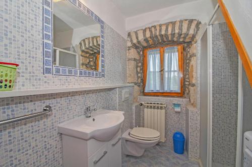 a bathroom with a sink and a toilet and a mirror at Erika in Šumber (Haus für 4-6 Personen) in Nedeščina
