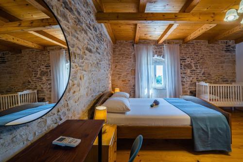 une chambre avec un grand lit dans un mur de pierre dans l'établissement Kutić in Štokovci (Haus für 10-15 Personen), à Svetvinčenat