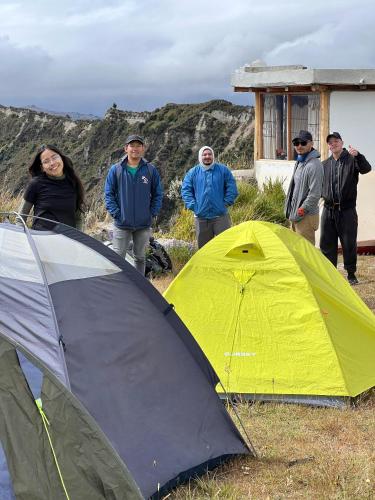 a group of people standing next to a tent at Urku Ñan Quilotoa in Sigchos