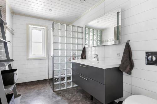 ein weißes Badezimmer mit Waschbecken und Spiegel in der Unterkunft 3716 Nexø - Granvej 12 in Snogebæk