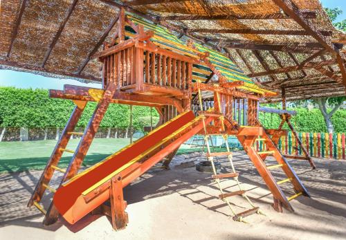 a wooden playground with a slide in the sand at JAZ Fanara Resort in Sharm El Sheikh