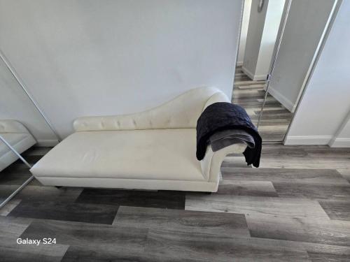 a white couch in a room with a black blanket at Private Balcony-Pet Friendly -City Access -Gaming in Burlington