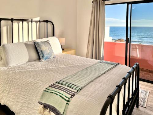 a bedroom with a bed with a view of the ocean at Oceanfront - Casita Rosa in Puerto Nuevo