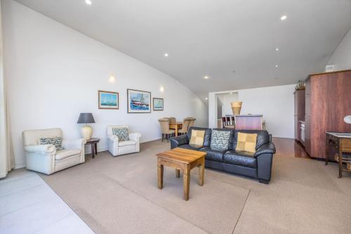 a living room with a couch and chairs and a table at QV Stays Waterfront Elegance on Princes Wharf in Auckland