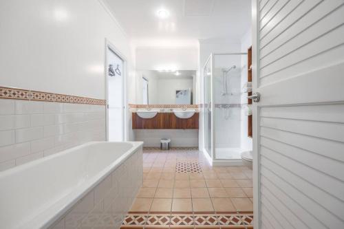 a white bathroom with a tub and a toilet at QV Stays Waterfront Elegance on Princes Wharf in Auckland