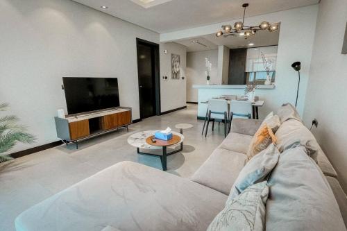 a living room with a couch and a table at Hive Stayz - 1 Bedroom in Catamaran Tower in Sanābis