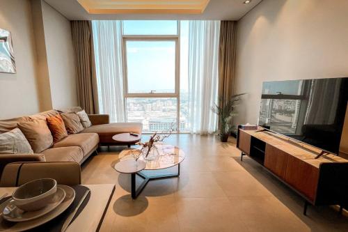 a living room with a couch and a flat screen tv at Hive Stayz - 1 Bedroom in Catamaran Tower in Sanābis