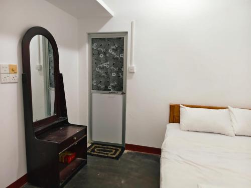 a bedroom with a bed and a mirror next to a bed at TR Rest House in Trincomalee