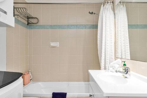 een badkamer met een wit bad en een wastafel bij Sandy Bottoms in Brunswick Heads