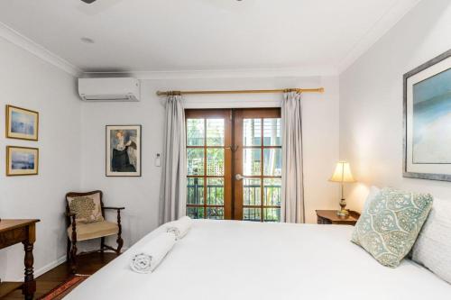 een slaapkamer met een groot wit bed en een raam bij Sandy Bottoms in Brunswick Heads