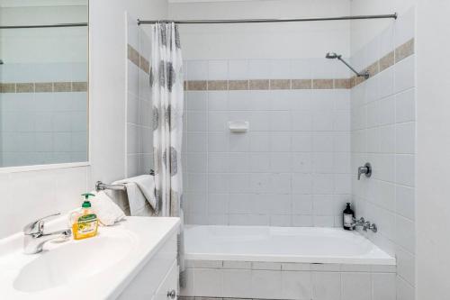 une salle de bain blanche avec une baignoire et un lavabo dans l'établissement Lil Nauti, à Brunswick Heads