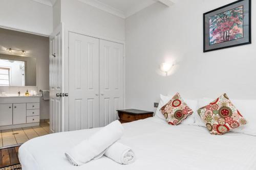 Cet appartement comprend une chambre avec 2 lits blancs et une cuisine. dans l'établissement Lil Nauti, à Brunswick Heads