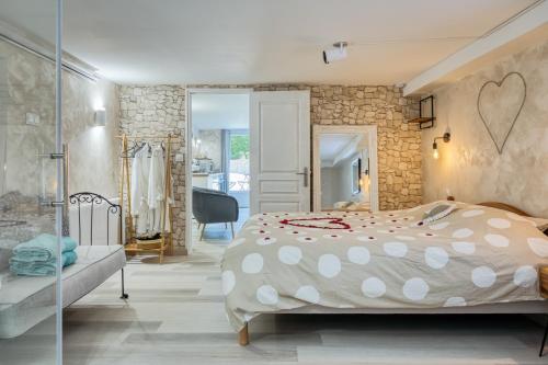 a bedroom with a bed and a stone wall at L'Escapade Enchantée - Spa, Cheminée et Cinéma in Tournedos-Bois-Hubert