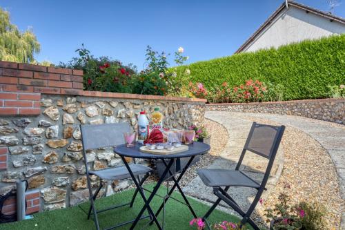 Tournedos-Bois-HubertにあるL'Escapade Enchantée - Spa, Cheminée et Cinémaの庭園内のテーブルと椅子2脚