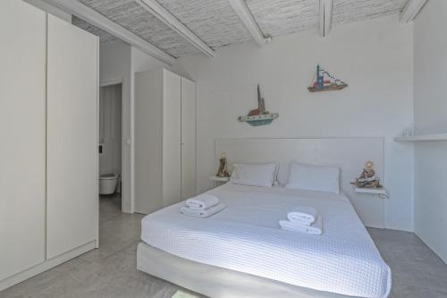 a white bedroom with a bed with two towels on it at Villa Nissos in Plakias
