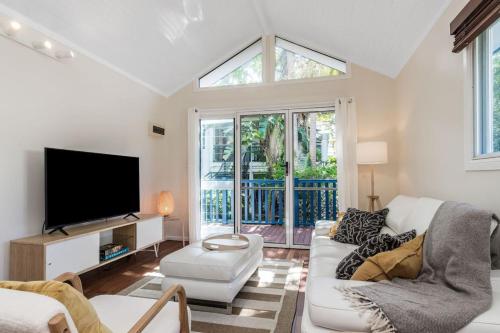 a living room with a white couch and a tv at Broadviews Secret Hideaway in Brunswick Heads