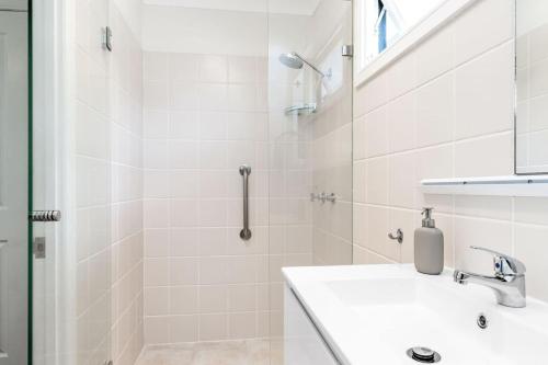 un bagno bianco con lavandino e doccia di Broadviews Secret Hideaway a Brunswick Heads