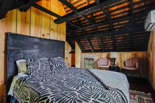 a bedroom with a bed in a room with wooden walls at Charming 2BR with Fire Pit on Farm - 10 Min to Wharf in Onancock