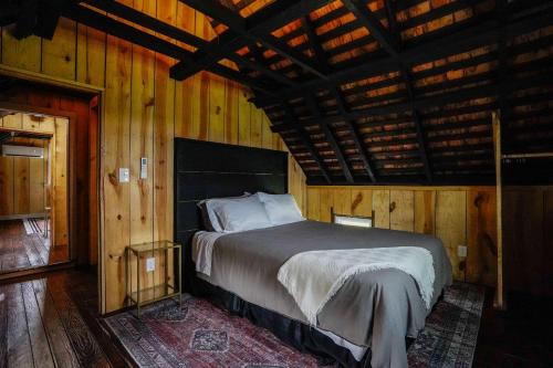 a bedroom with a bed in a wooden room at Charming 2BR with Fire Pit on Farm - 10 Min to Wharf in Onancock