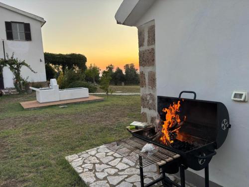 a barbecue grill with a fire in a yard at Il casale di Sere Tarquinia in Tarquinia