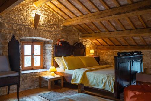 a bedroom with a bed in a stone room at Una in Kranjčići - Haus für 5-6 Personen in Svetvinčenat