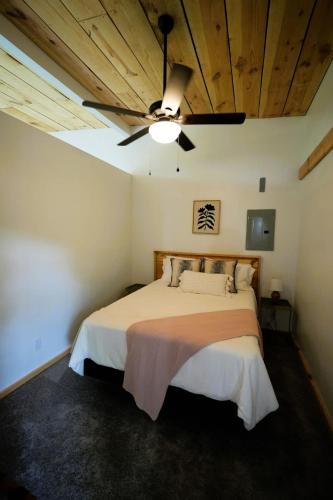 a bedroom with a bed with a ceiling fan at Luxe 2BR Cabin with Deck and Creek View - Working Farm in Onancock