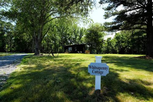 a sign in the middle of a field with a museum cottage at Luxe 2BR Cabin with Deck and Creek View - Working Farm in Onancock