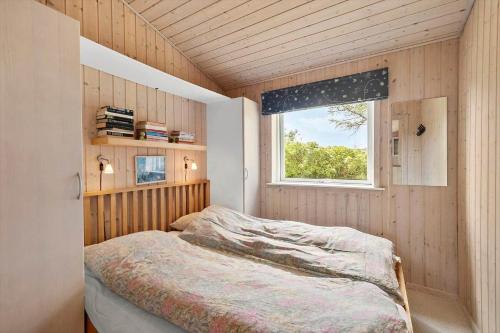 een slaapkamer met een bed in een kamer met een raam bij LN2032-Hjorring-Krattet-9 in Lønstrup