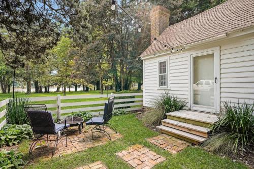 a house with two chairs and a porch with a car in the window at Sweet 1BDR Farm Cottage with Fire Pit and Creek View in Hacksneck