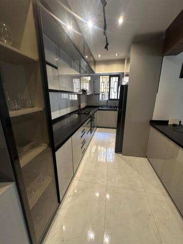 eine Küche mit weißen Schränken und einem Fliesenboden in der Unterkunft VESTA - Luxury APT - 3BR - Gardenia Residence in Kairo