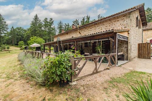 a brick building with a fence in front of it at Villa Les Touilles - Dordogne in Piégut-Pluviers