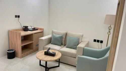 a living room with a couch and a table and a chair at فندق رافيليا Rafellia Hotel in Ahad Rafidah