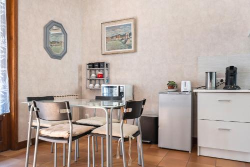 a kitchen with a table with chairs and a microwave at studio maupas in Vienne