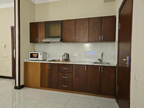 a kitchen with wooden cabinets and a microwave at Crown Suites in Baku