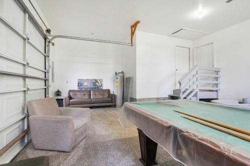 a room with a ping pong table and a couch at Spacious 3BR with Dock on Working Farm with Pool Table in Hacksneck