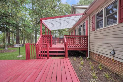 a red deck on the side of a house at Spacious 3BR with Dock on Working Farm with Pool Table in Hacksneck