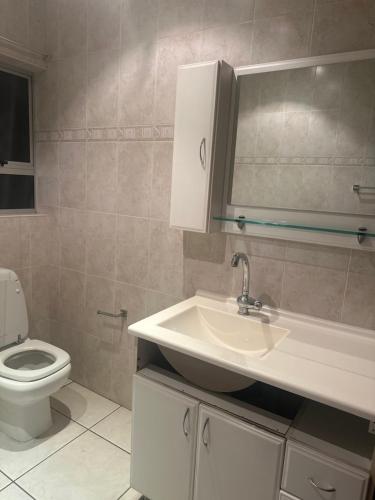 a bathroom with a sink and a toilet at Die Heuwel Luxury Suites in Witbank