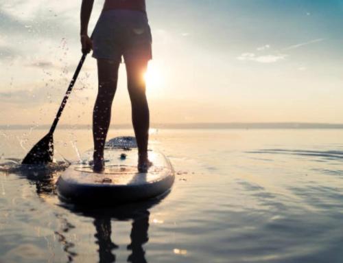 a person standing on a paddle board in the water at Spacious 3BR with Dock on Working Farm with Pool Table in Hacksneck