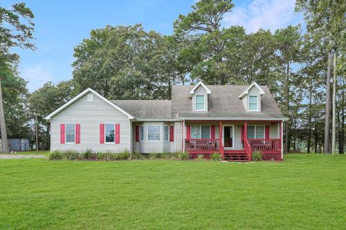 a white house with red trim on a green lawn at Spacious 3BR with Dock on Working Farm with Pool Table in Hacksneck