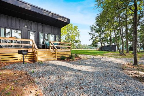a home with a large porch and a house at Waterfront 1BR on Working Farm with Deck and View in Hacksneck
