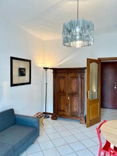 Una sala de estar con un sofá azul y una mesa. en Casa Margaret, en Verbania