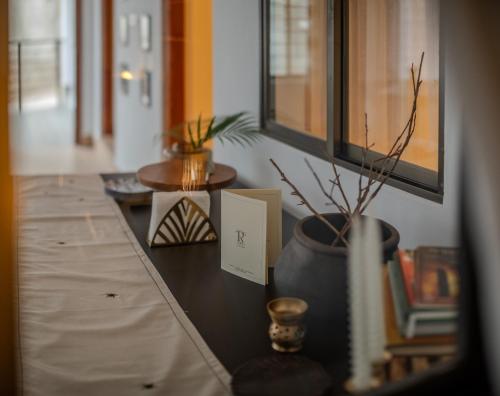 a table with a potted plant and a card on it at Rijied Bed and Breakfast in Shillong
