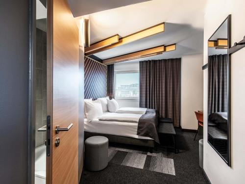 a hotel room with a bed and a window at B&B HOTEL München-Messe in Aschheim