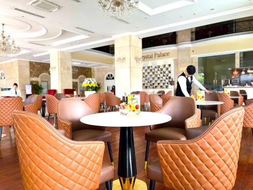 Un hombre de pie en un restaurante con mesas y sillas. en Golden King, en Ho Chi Minh