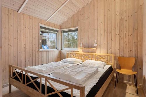 una camera da letto con un letto e una sedia di TV1683-Strandby-Bygmarken-2 a Bratten Strand