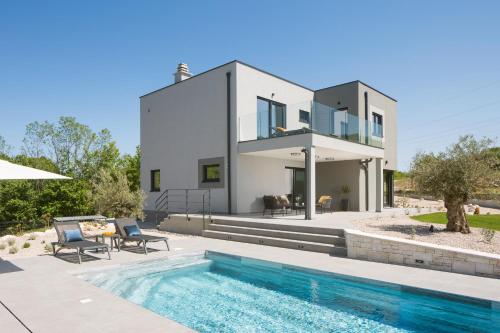 a villa with a swimming pool and a house at Villa Tia in Kukurini - Haus für 8 Personen in Pićan